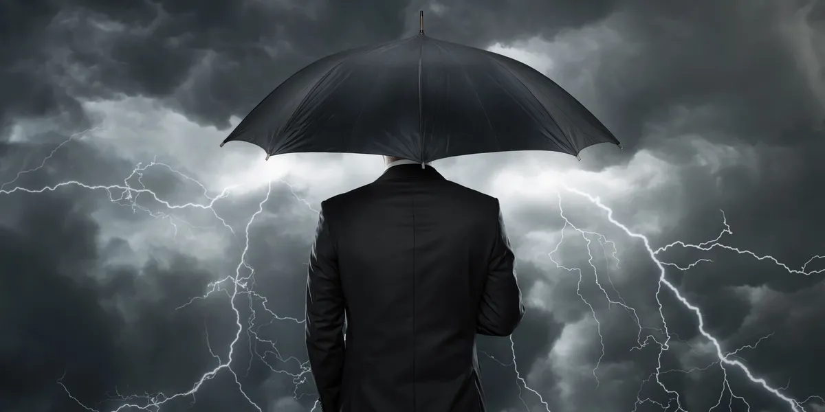 Silhouetted figure with umbrella against stormy sky